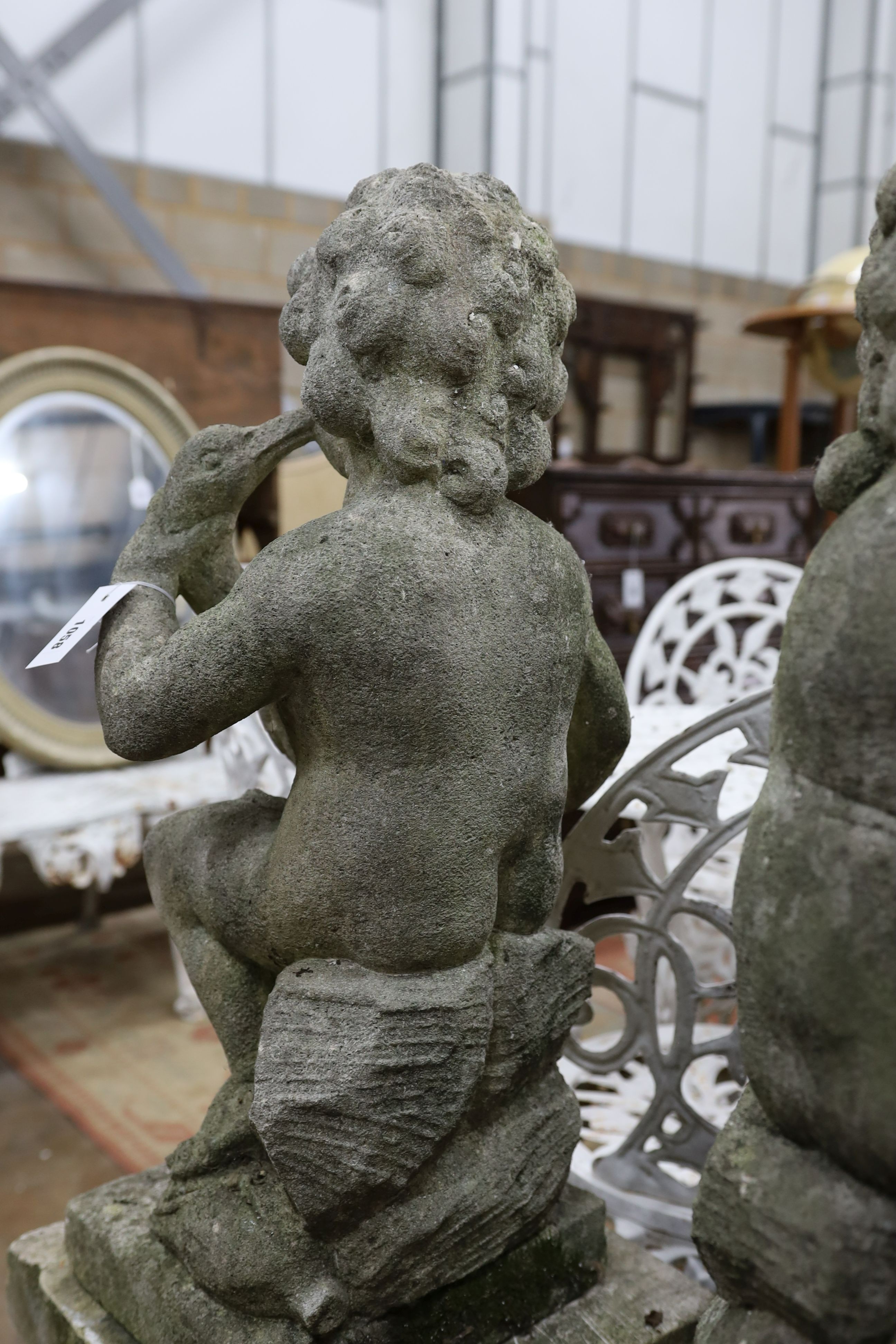 A pair of reconstituted stone cherub and dove garden ornaments on faux marble plinths, height 116cm